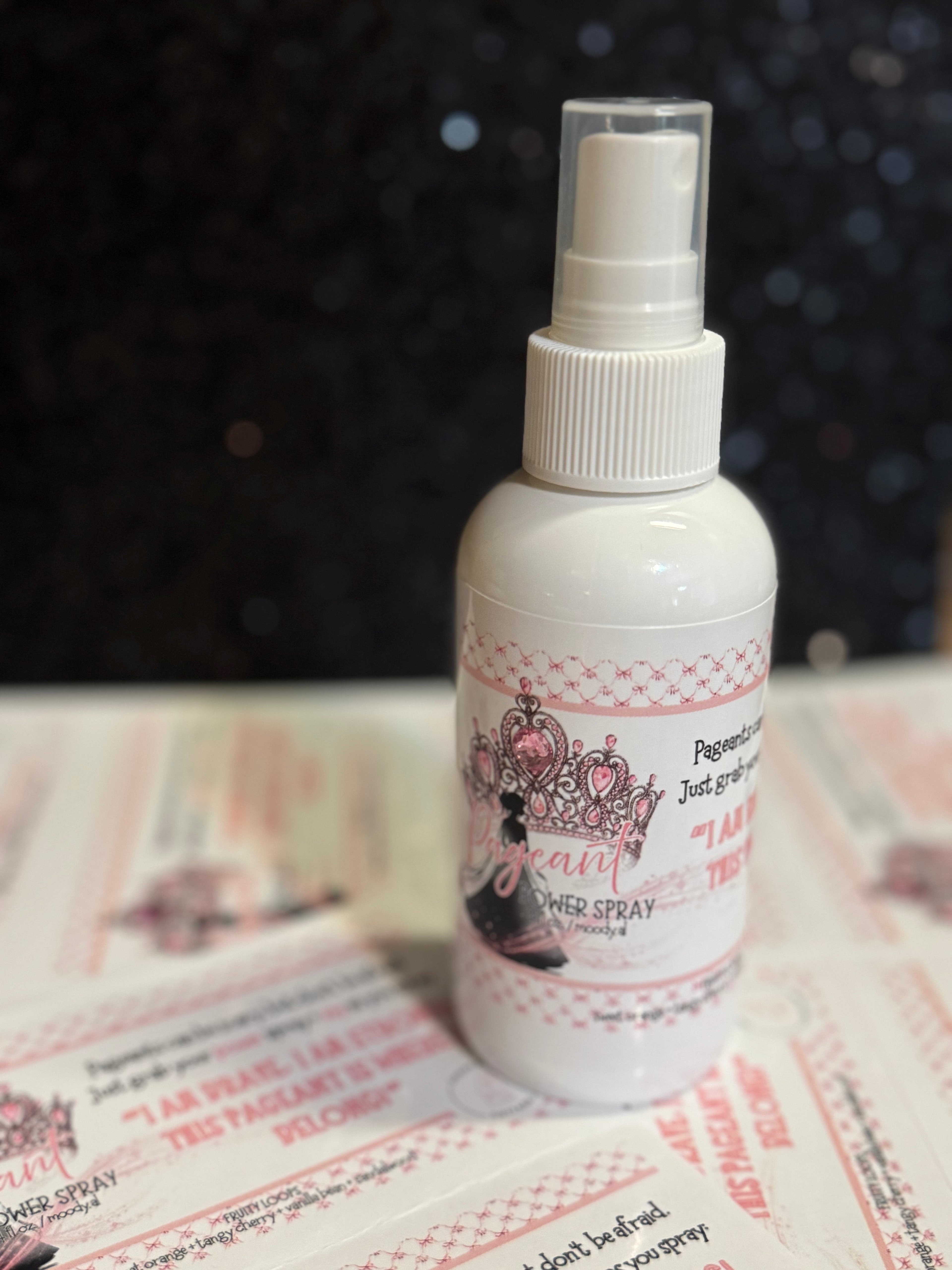 White spray bottle with decorative label on a textured surface