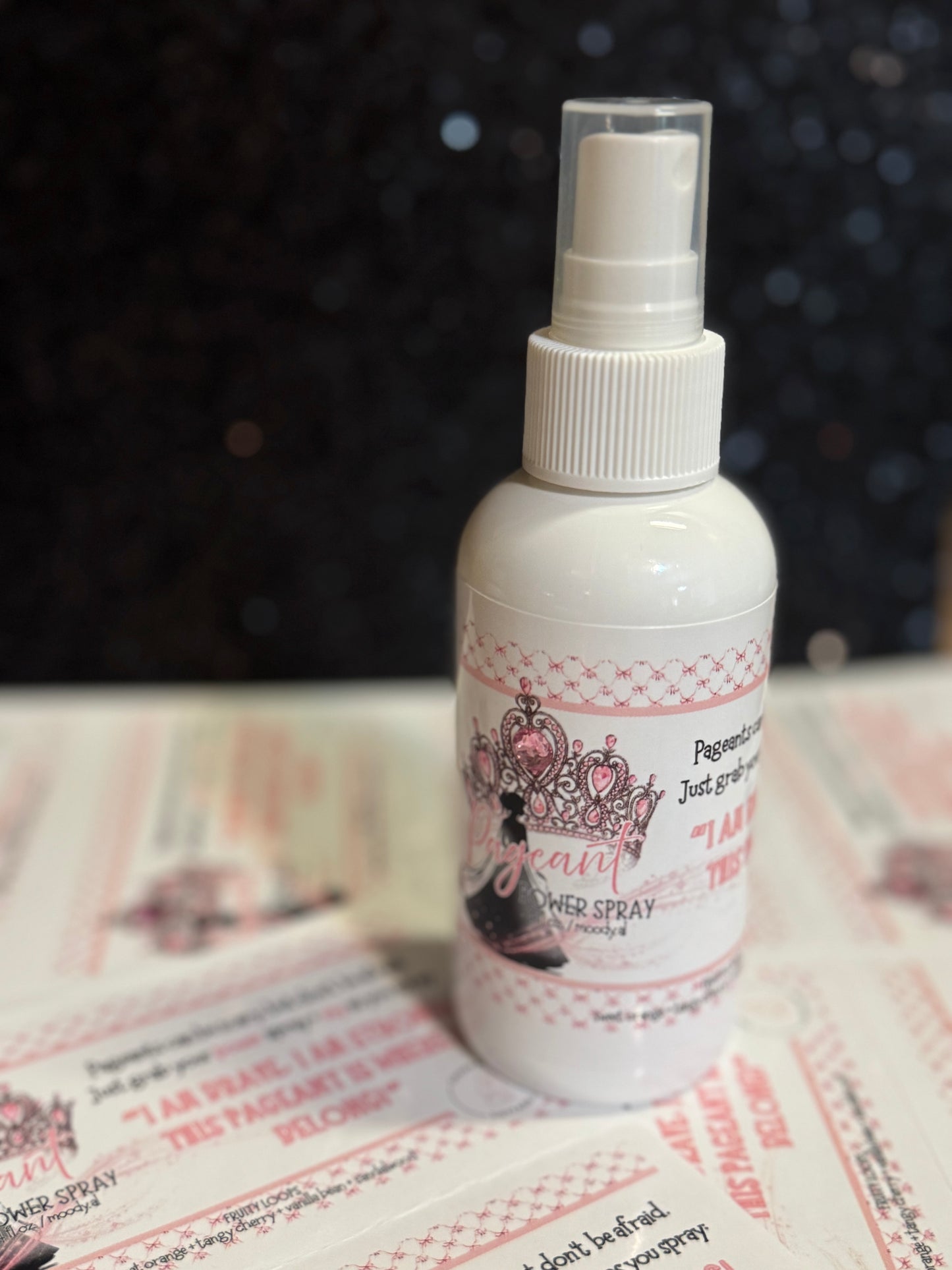 White spray bottle with decorative label on a textured surface
